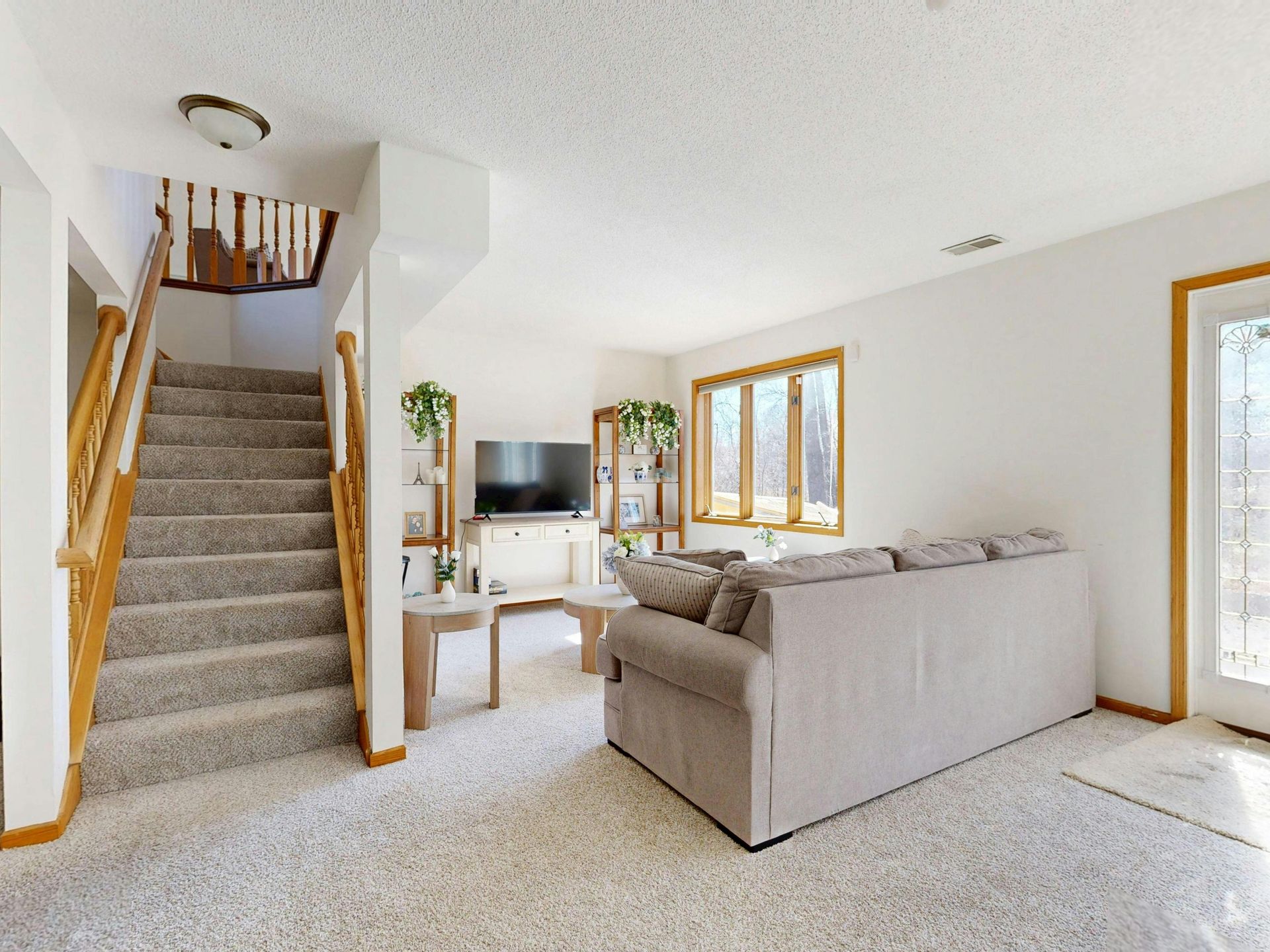 Inviting living room with cozy sofa and natural light through large windows.